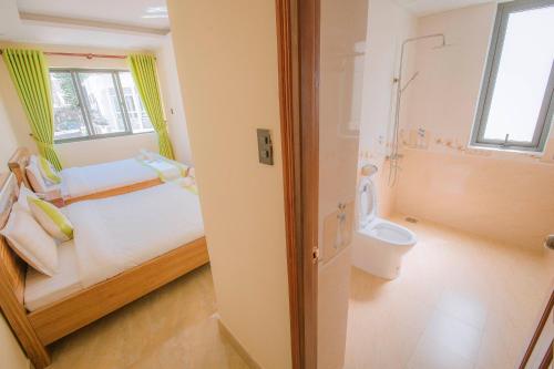 uma pequena casa de banho com uma cama e um WC em Latipha Hotel em Da Lat