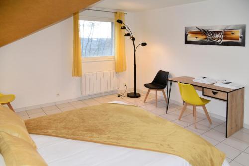 una camera da letto con scrivania, letto e tavolo con sedie di Villa pré d'Oro - 1000 étangs a Amage