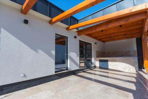 a patio of a house with a wooden roof at PontJó Apartman Miskolc in Miskolc