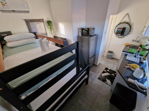Dormitorio pequeño con cama y nevera en Casa-Pel Tiny House, en Palapye