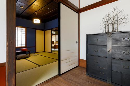 a room with a closet with a mirror and a bedroom at Machi no Odoriba in Kanazawa