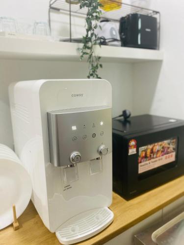 a white coffee maker on a counter next to a microwave at Homestay Alor Setar Nearby Hospital Sultanah Bahiyah in Alor Setar