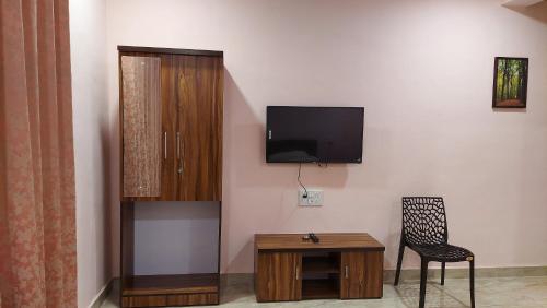 a room with a tv and a chair and a table at Soham Beach Resort, Diveagar in Diveagar
