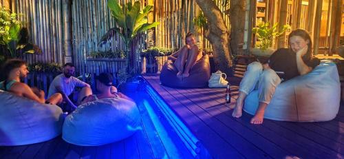 un groupe de personnes se posant sur des poufs à côté d'une piscine dans l'établissement Aha Lanta Cozy Hostel, à Ko Lanta