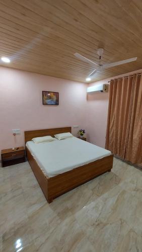 een slaapkamer met een groot bed en een houten plafond bij Soham Beach Resort, Diveagar in Diveagar