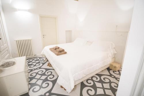a white bedroom with a bed with towels on it at Sui Tetti Luxury Rooms in Lecce