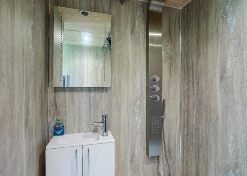 a bathroom with a sink and a mirror at Riverside Cabins in Shrewsbury
