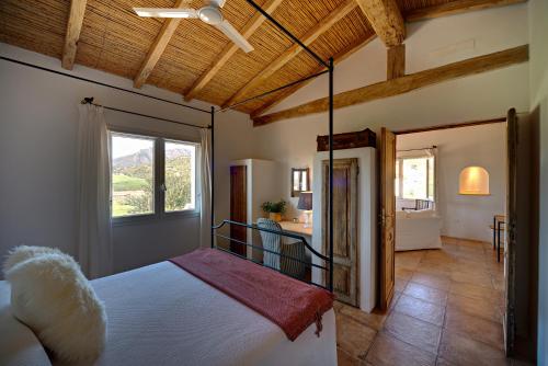 een slaapkamer met een groot bed en een raam bij Auberge Santu Martine - Cottage with Pool - Ischierda in Galtellì