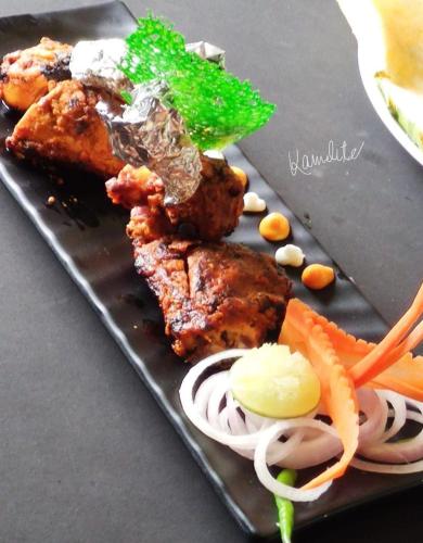 a plate of food with meat and vegetables on a table at The Kannelite in Jamshedpur