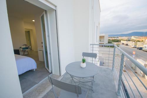 a balcony with a table and chairs and a bed at Artemisia Home in Olbia