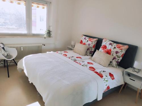 a bedroom with a large bed with red flowers on it at Apartment Waldblick - 77 qm, 2 Schlafzimmer, Balkon und Wi-Fi in Maulburg
