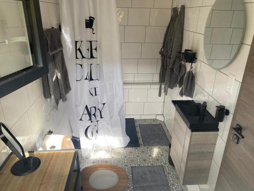 a bathroom with a shower curtain and a toilet at LaCabane in Cormondreche