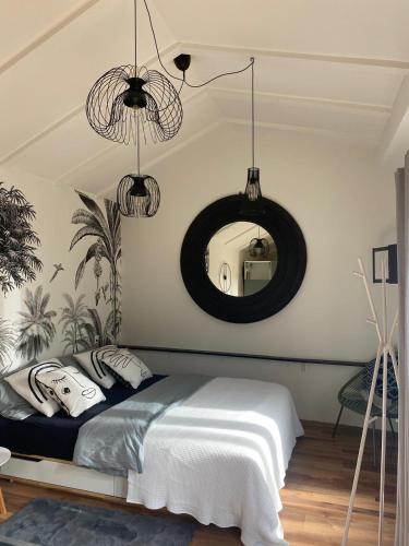 Un dormitorio con una cama y un espejo en la pared. en LaCabane, en Cormondreche
