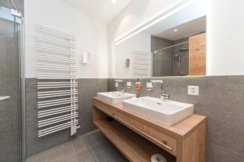 a bathroom with two sinks and a shower at Bel`Laret in Samnaun