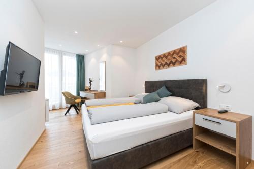 een woonkamer met een bed en een televisie bij Bel`Laret in Samnaun