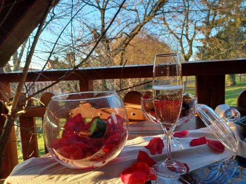 a table with two glasses of wine and flowers on it at Gite avec SPA privé in Drulingen