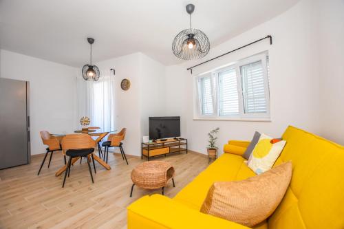 een woonkamer met een gele bank en een tafel bij Lavanda in Mandre