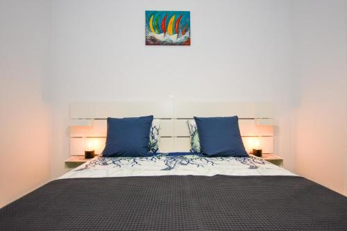 een slaapkamer met een groot bed met blauwe kussens bij Lavanda in Mandre