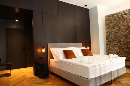 a bedroom with a large white bed with brown pillows at Welkam in Poprad