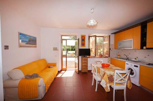 a kitchen with a couch and a table in a room at Villa Aiali in Marina di Campo