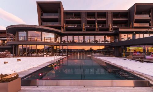 - un grand bâtiment avec une piscine en face dans l'établissement Hotel Chalet Mirabell, à Avelengo