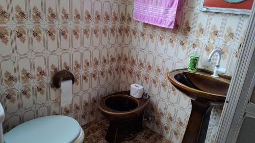 a bathroom with a toilet and a sink at Hostel Meu Cantinho Caxambu Mg in Caxambu