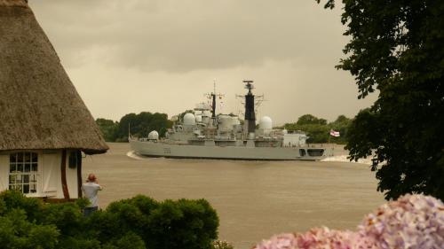 a large boat on a river with a person standing in front at La Bonne Auberge - Seine Panorama SAS in Vieux-Port