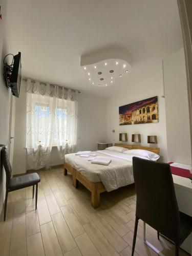 a bedroom with a bed and a chair in it at Vapama Rooms in Verona