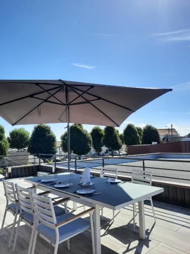 a table and chairs under an umbrella on a roof at Appartement au Crotoy in Le Crotoy