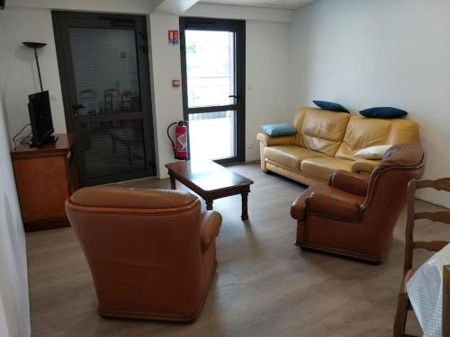 Appartement au Crotoy في لو كروتوي: غرفة معيشة مع كرسيين وأريكة
