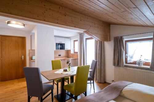 a dining room with a table and chairs and a bed at Ferienhaus Olympia in Lermoos