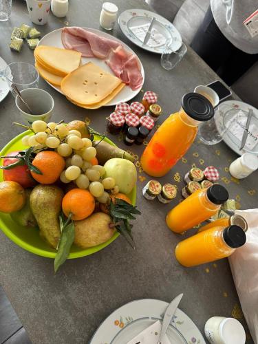a table with a plate of fruit and orange juice at Le Paradis d'Henri in Hannut