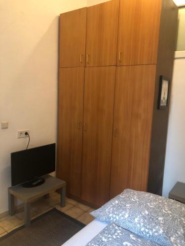 a bedroom with a bed and a large wooden cabinet at RoooMS by JR City Apartments in Vienna