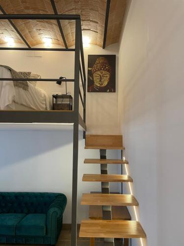 Cette chambre dispose d'un escalier et d'un canapé vert. dans l'établissement Loft en Montjuic, à Barcelone