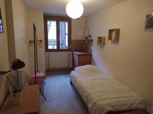 Schlafzimmer mit einem Bett, einem Schreibtisch und einem Fenster in der Unterkunft chey MYBAM, agréable maison au centre de Sélestat in Sélestat
