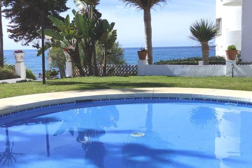a swimming pool with the ocean in the background at ALGAIDA BEACHFRONT - Seaview Costa del sol in Sitio de Calahonda