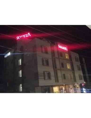 a building with neon signs on the side of it at Hotel Solista, Chittorgarh-312001, in Chittaurgarh