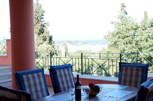 a table with a bottle of wine and chairs on a balcony at StarLight SeaView in Gouvia