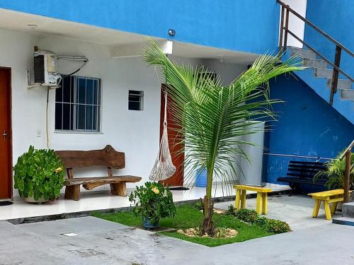 a house with a palm tree and a bench at Hospedaria da Praia Fortaleza in Fortaleza