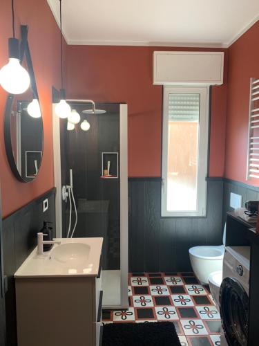 a bathroom with a sink and a toilet and a mirror at Design studio Margherita in Cinisello Balsamo