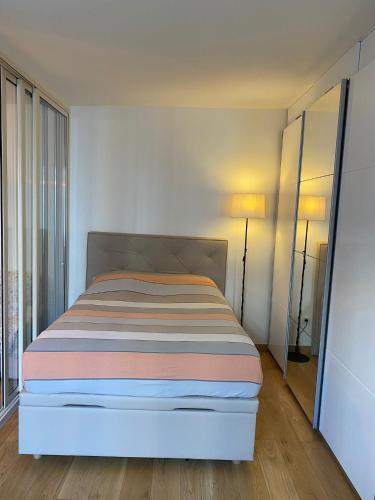 a bedroom with a bed with a striped blanket at Ollya in Paris