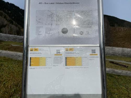 a sign in the grass next to a fence at Disentis in Disentis