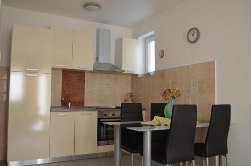 a kitchen with a table and chairs in a room at Apartments Ivana in Baška