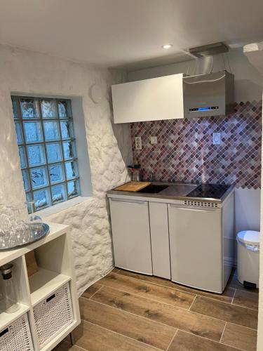 eine Küche mit weißen Schränken und einem Waschbecken in der Unterkunft Apartment Bergen sentrum in Bergen