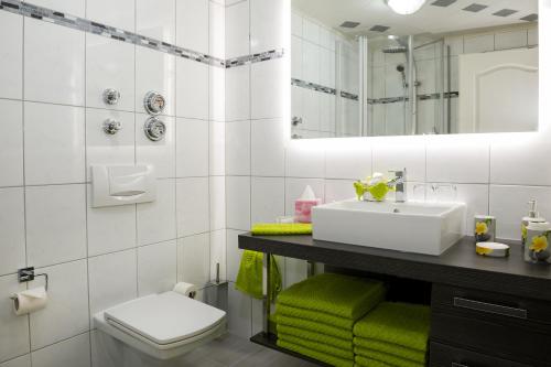 ein Badezimmer mit einem Waschbecken, einem WC und einem Spiegel in der Unterkunft Ferienwohnungen Am Markt in Rüdesheim am Rhein