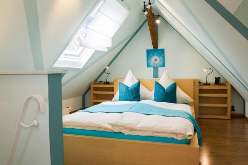 Schlafzimmer mit einem Bett mit blauen und weißen Kissen in der Unterkunft Ferienwohnungen Am Markt in Rüdesheim am Rhein