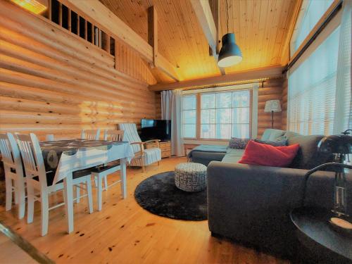 ein Wohnzimmer mit einem Sofa und einem Tisch in der Unterkunft Holiday Home Honkakoli 1 in Kolinkylä