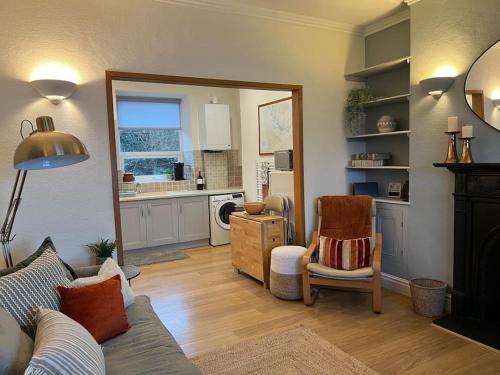 a living room with a couch and a kitchen at Harbourside 2 Bed apartment, Barmouth Bridge Views in Barmouth