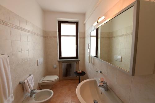 uma casa de banho com um lavatório, WC e um espelho. em Hotel Villa Lauri em Neive