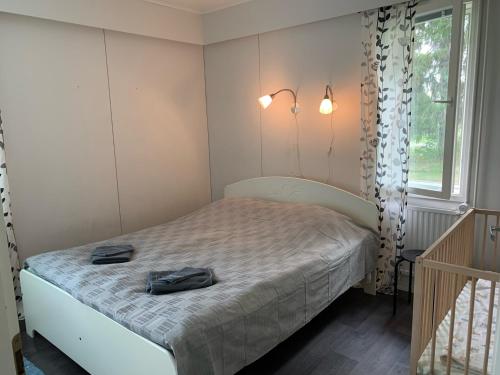 Un dormitorio con una cama con un par de zapatos. en Tomujoen Kylätalo, en Himanka